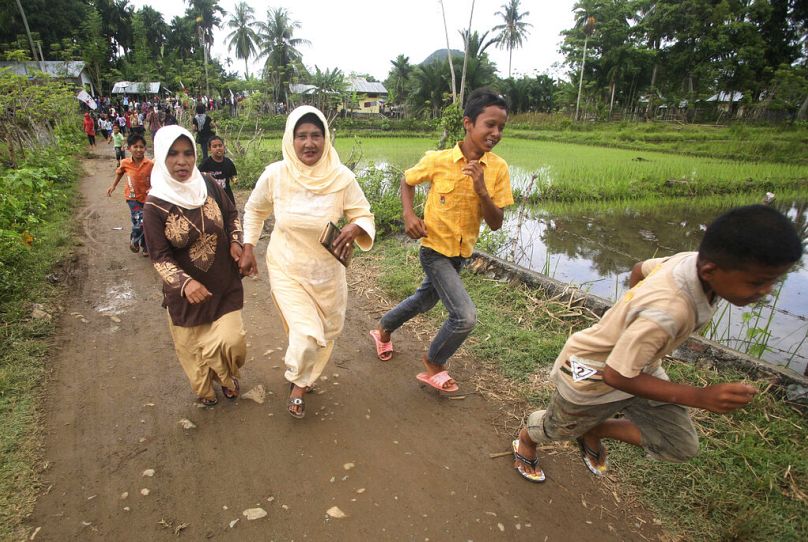 People run to higher ground during a tsunami drill on the fifth anniversary of the Indian Ocean tsunami in Lhoong, Aceh province, Indonesia, in 2009.