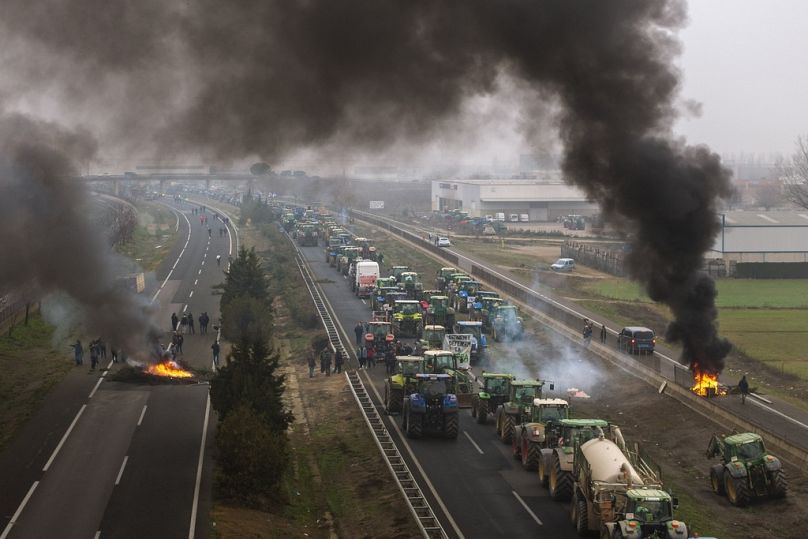Agricultores fazem barricadas depois de bloquearem uma autoestrada durante um protesto perto de Mollerussa, em Espanha