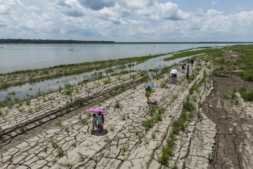 Kolombiya'nın Santa Sofia kentinde insanlar kuraklık belirtileri gösteren Amazon Nehri'nin bir bölümünde yürüyor.