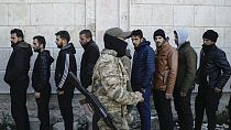 Members from Bashar Assad's Syrian army period line up to register with Syrian rebels as part of a "identification and reconciliation process" at a army compound in Latakia