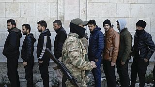 Membri del periodo dell'esercito siriano di Bashar Assad si mettono in fila per registrarsi presso i ribelli siriani come parte di un «processo di identificazione e riconciliazione» in un complesso militare a Latakia