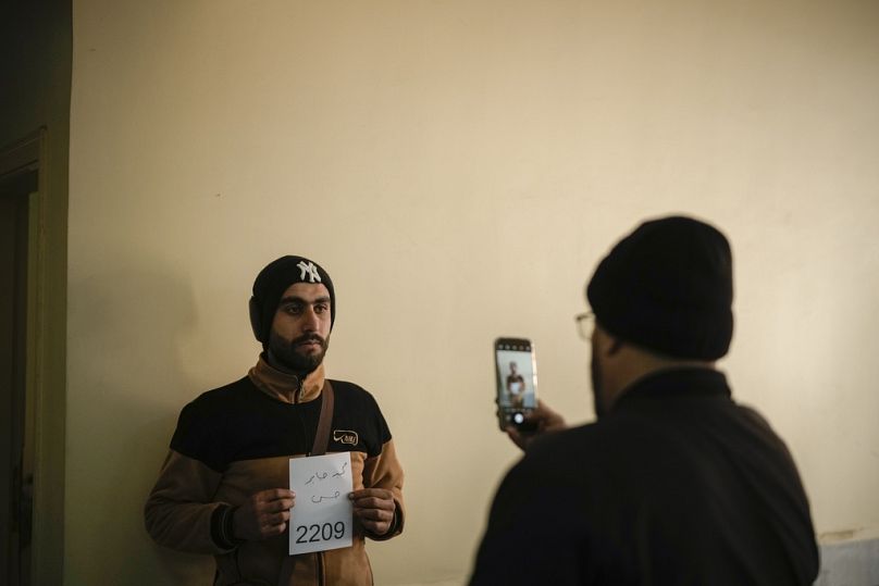 A member of Bashar Assad's army or a pro-government militia registers with Syrian rebels as part of an "identification and reconciliation" process at a compound in Latakia