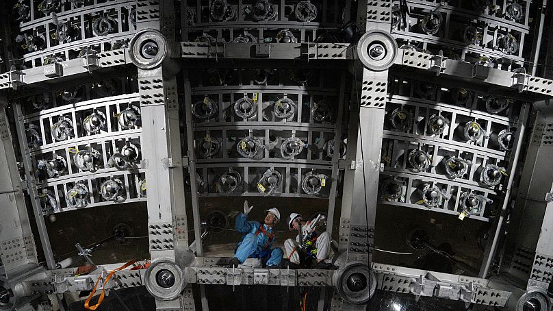 Workers labour on the underside of the cosmic detector located 700 m underground at the Jiangmen Underground Neutrino Observatory in Kaiping, southern China.