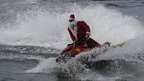 A fireman dressed as Father Christmas drives a jet ski on Copacabana beach in Rio de Janeiro, 17.12.2024