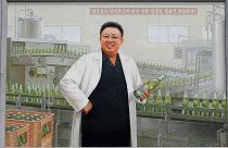A mural of the late North Korean leader Kim Jong Il in a white lab coat holding up a bottle of beer is seen at the entrance of the Taedonggang Brewery in Pyongyang, 