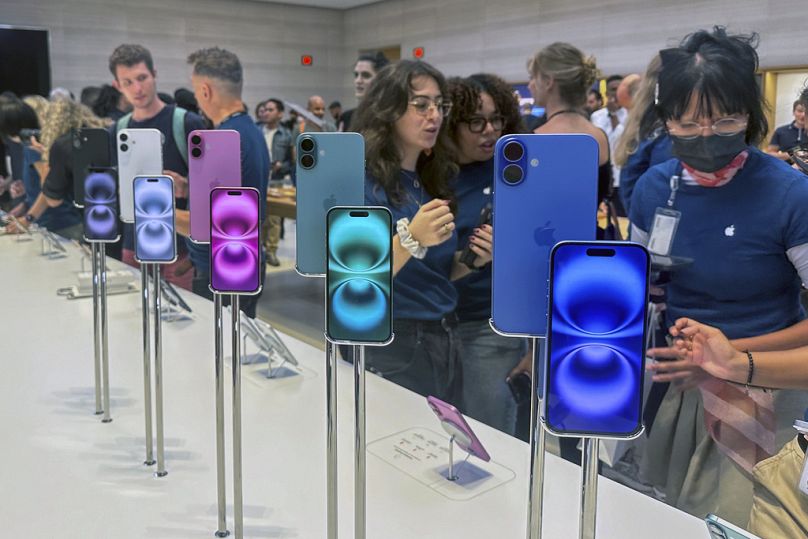 Persone vicino a un espositore di iPhone 16 all'Apple Store sulla 5th Avenue di New York, 20 settembre 2024