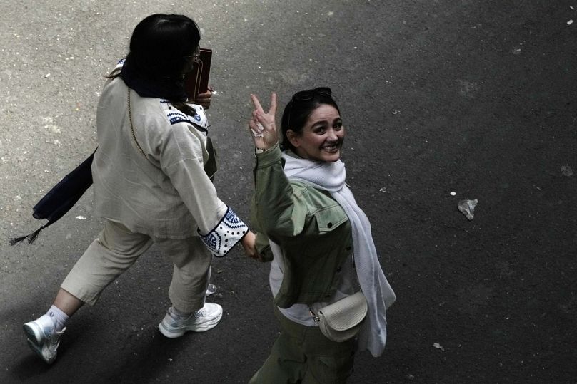 امرأة إيرانية لا تظهر وهي لا تردي الحجاب الذي يعتبر إلزاميا هناك وترفع علامة النصر أثناء سيرها في طهران بإيران 13 حزيران يونيو 2024