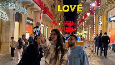 Young people taking a photo in front of the illuminations with messages of hope, Beirut, Lebanon, 17.12.2024