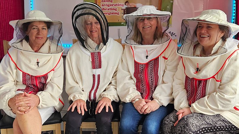 Los visitantes se visten con trajes de apicultor antes de la experiencia de la cama de abejas.