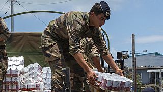 A French Army soldier unloading cans of food in the Indian Ocean French territory of Mayotte, Wednesday Dec.18, 2024