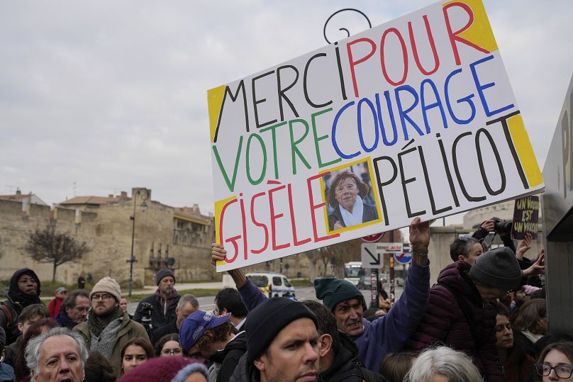 A man holds a placard reading "Thank you for your courage Gisele Pelicot" outside the Avignon courthouse, southern France, Thursday, Dec. 19, 2024.