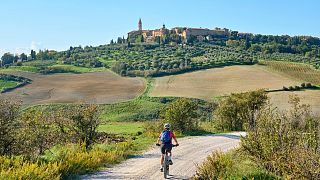 Ciclista nella regione del Chianti vicino alla città medievale di Pienza, Toscana, Italia