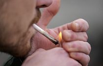 A man smokes cannabis in Cologne, Germany, at a public consumption event at the start of a new law in April 2024. 