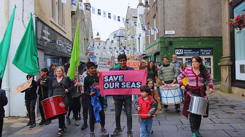 Sanjeev, Andrea and other activitists march through Shetland's streets