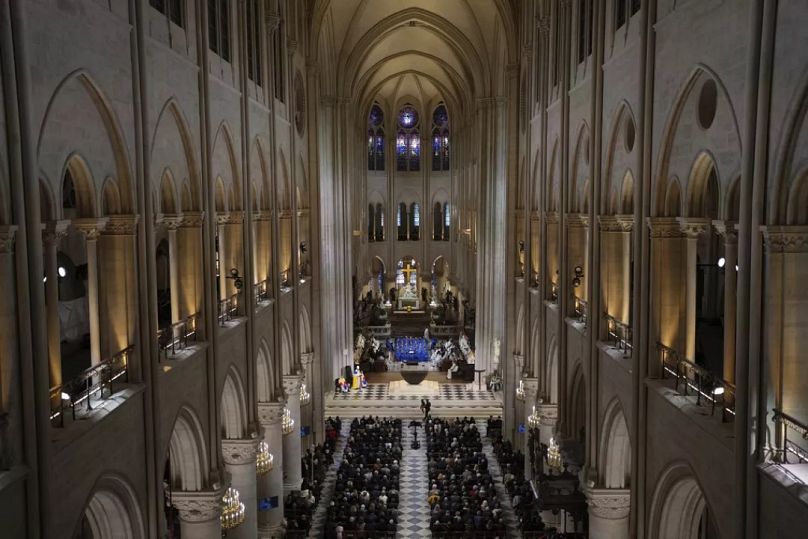 Guest attend the service in Notre Dame Cathedral as France's iconic cathedral is formally reopening its doors for the first time since a devastating fire 