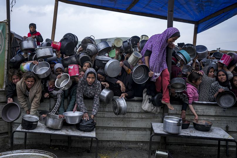 Mujeres y niñas palestinas luchan por conseguir alimentos en un centro de distribución en Jan Yunis, Franja de Gaza, el viernes 20 de diciembre de 2024.