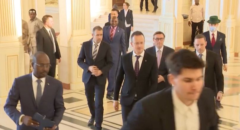 Orbán Gáspár kalapban és arcmaszkkal a magyar külügyminiszteri küldöttség n’djamenai látogatásán, 2023 decemberében