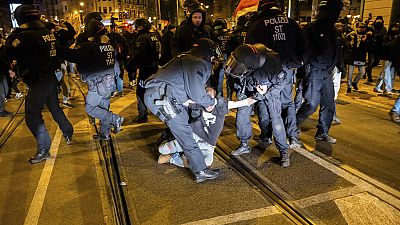 A man is taken away by police officers during a demonstration by right-wing groups in Magdeburg, Germany, Saturday, Dec. 21, 2024. (Christoph Soeder/dpa via AP)