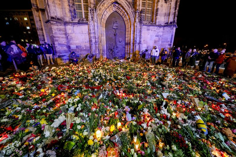 Des personnes ont déposé des fleurs et des bougies devant l'église Johannis, près du marché de Noël, où une voiture a foncé dans la foule vendredi soir, à Magdebourg, 21.12.24