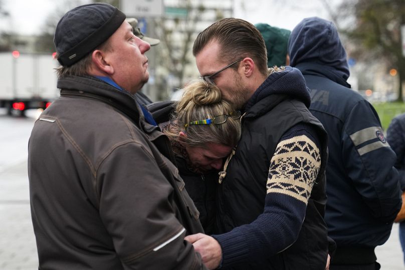 Des gens s'embrassent en pleurant les victimes près du marché de Noël, où une voiture a foncé dans la foule vendredi soir, à Magdebourg, en Allemagne, dimanche 22.12.2024