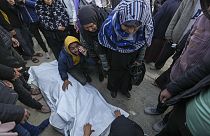 Relatives and neighbours mourn over the body of one of the victims of an Israeli strike on a hom4 late Saturday as they are prepared for the funeral outside the Al-Aqsa Martyr