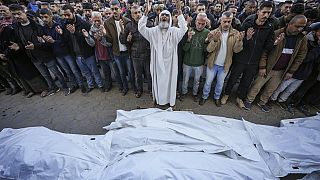 Palestinesi pregano sui corpi delle vittime di un attacco israeliano contro un'abitazione, sabato scorso, prima del funerale all'esterno dell'Ospedale dei Martiri di Al-Aqsa a Deir al-Balah, 22 dicembre 2024.