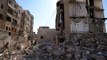 Syrian children play next to a destroyed residential building at Hanano neighbourhood in the city of Aleppo, Syria.