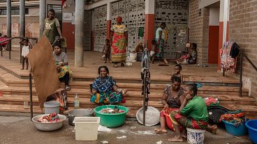 Women wash clothes after a short rain filled their pots with water, at the Lycée des Lumières where they found shelter after losing their homes, in Mamoudzou, Mayotte, Dec. 19