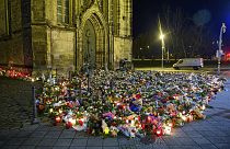 Flowers, candles, wreaths and stuffed animals lie in front of St. John's Church, Monday, Dec. 23, 2024, in Madgeburg, Germany, after a car drove into a Christmas market 
