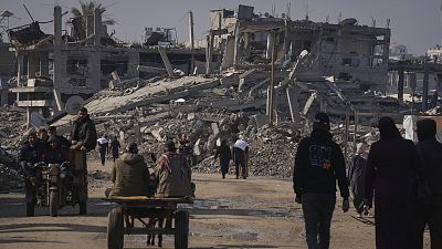  Palestinians carry U.N.-donated flour in Khan Younis, central Gaza Strip, on Saturday Dec. 14, 2024.