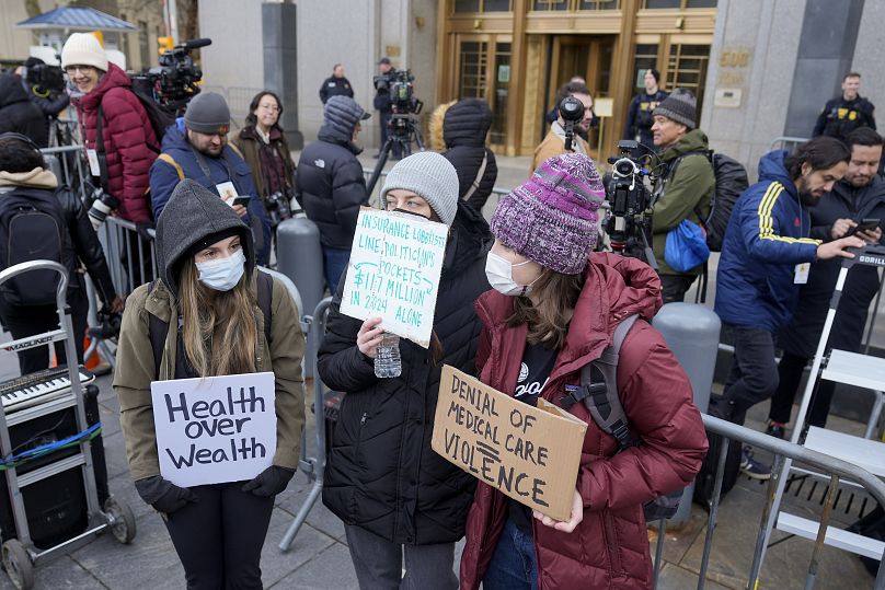 Des manifestants se tiennent devant le tribunal fédéral de Manhattan peu après l'arrivée de Luigi Mangione pour une audience, le jeudi 19 décembre 2024, à New York.