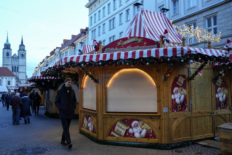 People walk at the Christmas Market, where a car drove into a crowd on Friday evening, in Magdeburg, Germany, Sunday, Dec. 22, 2024. 