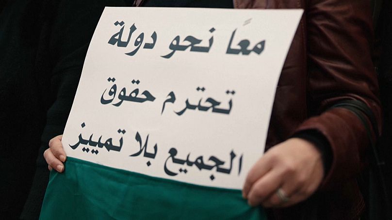 يافطة كتب عليها "معا نحو دولة تحترم حقوق الجميع بلا تمييز" رفعت خلال وقفة احتجاجية نسائية في دمشق 