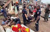 Medics tending to children as firefighters and security forces conduct search and rescue work