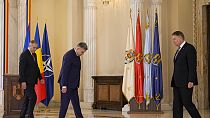 Romanian Prime Minister Marcel Ciolacu, and Romanian President Klaus Iohannis look for their designate places for a family picture after a swearing in ceremony