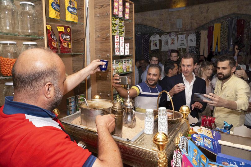 الرئيس السوري بشار الأسد، يحتسي القهوة أثناء زيارته لسوق في مدينة حلب القديمة، سوريا، الجمعة، 8 يوليو/تموز 2022