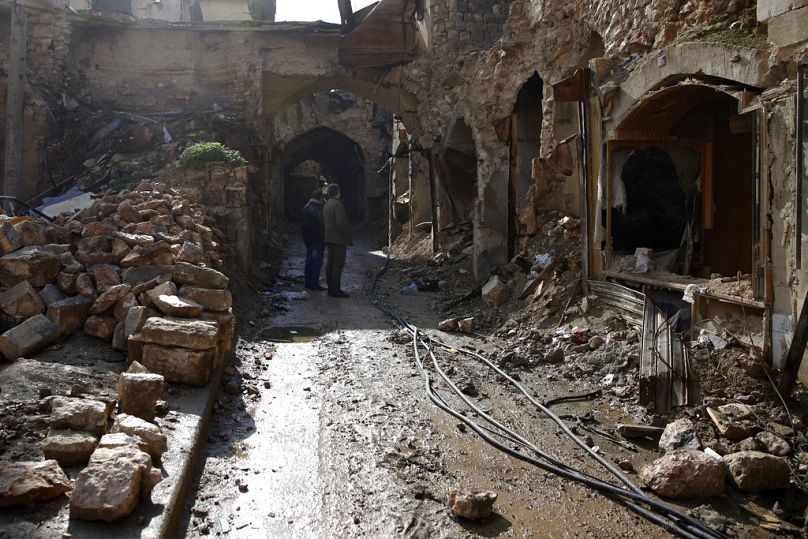رجال سوريون يتفقدون الدمار الذي لحق بالسوق القديم في مدينة حلب القديمة، سوريا، يوم الخميس، 18 كانون الثاني/يناير 2018، 