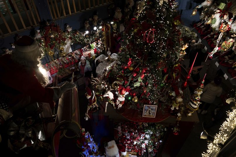 A child looks up at a Santa Claus figure on a sled at Kris Kringl