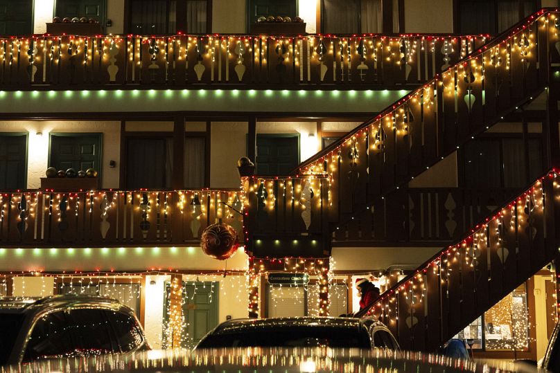A person wearing a Christmas themed hat walks down the steps at Obertal Inn
