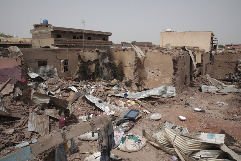 رجل يسير بجوار منزل تعرض للقصف في القتال الأخير في الخرطوم بالسودان وهي منطقة مزقتها المعارك بين الجيش وقوات الدعم السريع 25 نيسان إبريل 2023