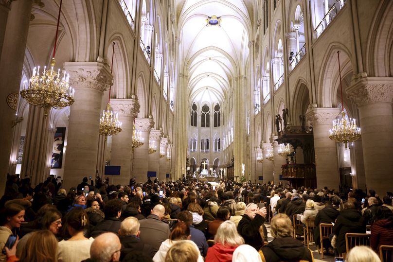 Faithful sit before the mass at Notre Dame Cathedral as the monuments hosts Christmas Eve services for the first time since a devastating 2019 fire, Tuesday, Dec. 24, 2024