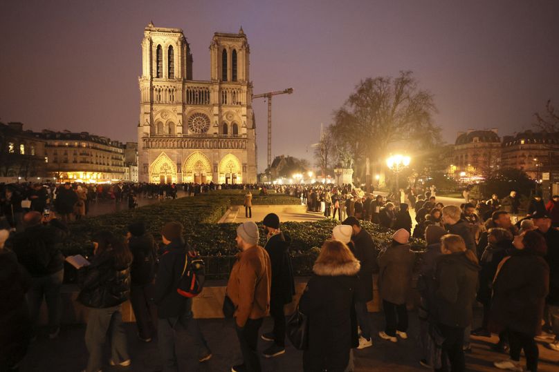 People queue to attend the mass at Notre Dame Cathedral as the monuments hosts Christmas Eve services for the first time since a devastating 2019 fire, Tuesday, Dec. 24, 2024