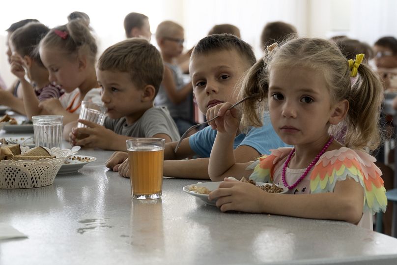 Children from an orphanage in the Donetsk region, eat a meal at a camp in Zolotaya Kosa, the settlement on the Sea of Azov, Rostov region, southwestern Russia, Friday, July 8,
