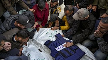 Relatives and friends mourn over the bodies of five Palestinian journalists who were killed by an Israeli airstrike in Gaza City, Thursday, Dec. 26, 2024.