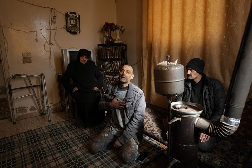 حسين عربيني يتوسط والدته وشقيقه في حي زملكا على مشارف دمشق بسوريا 25 كانون الأول ديسمبر 2024
