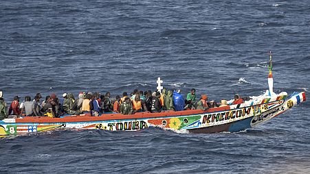 Os migrantes enchem um barco de madeira enquanto navegam para o porto de La Restinga, na ilha canária de El Hierro, em Espanha, segunda-feira, 19 de agosto de 2024. 