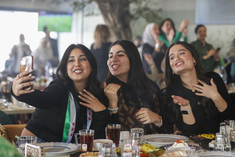 فتيات سوريات يرتدين أوشحة بألوان علم المعارضة السورية أثناء احتفال في مطعم في دمشق 17 كانون الأول ديسمبر 2024