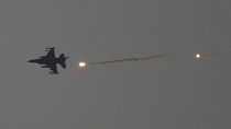 An Israeli fighter jet releases flares as it flies over the Gaza Strip, as seen from southern Israel, 16 January 2024