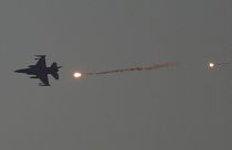 An Israeli fighter jet releases flares as it flies over the Gaza Strip, as seen from southern Israel, 16 January 2024