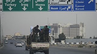 Combattenti siriani viaggiano su veicoli, mentre pattugliano un'autostrada, a Damasco, in Siria, giovedì 26 dicembre 2024.